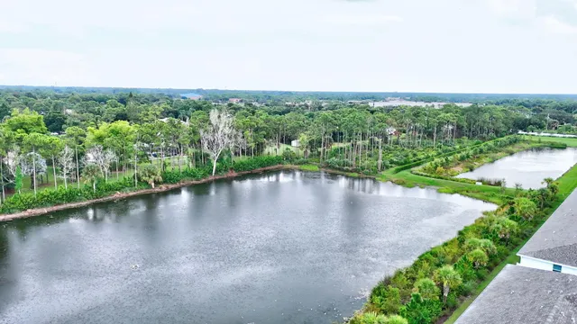 an aerial view of a house with a garden and lake view