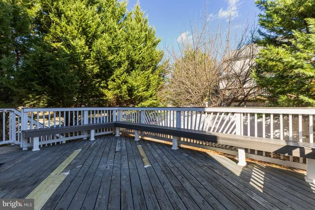 a balcony with wooden floor table and chairs