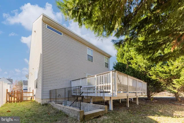 a view of a house with a yard balcony and a tree