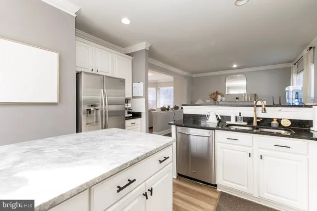 a kitchen with stainless steel appliances granite countertop a sink a stove a refrigerator and cabinets