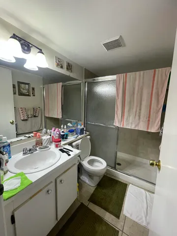 a bathroom with a sink mirror vanity and toilet