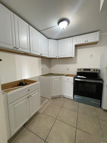 a kitchen with a stove sink and cabinets