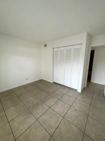 an empty room with a bench and cabinet