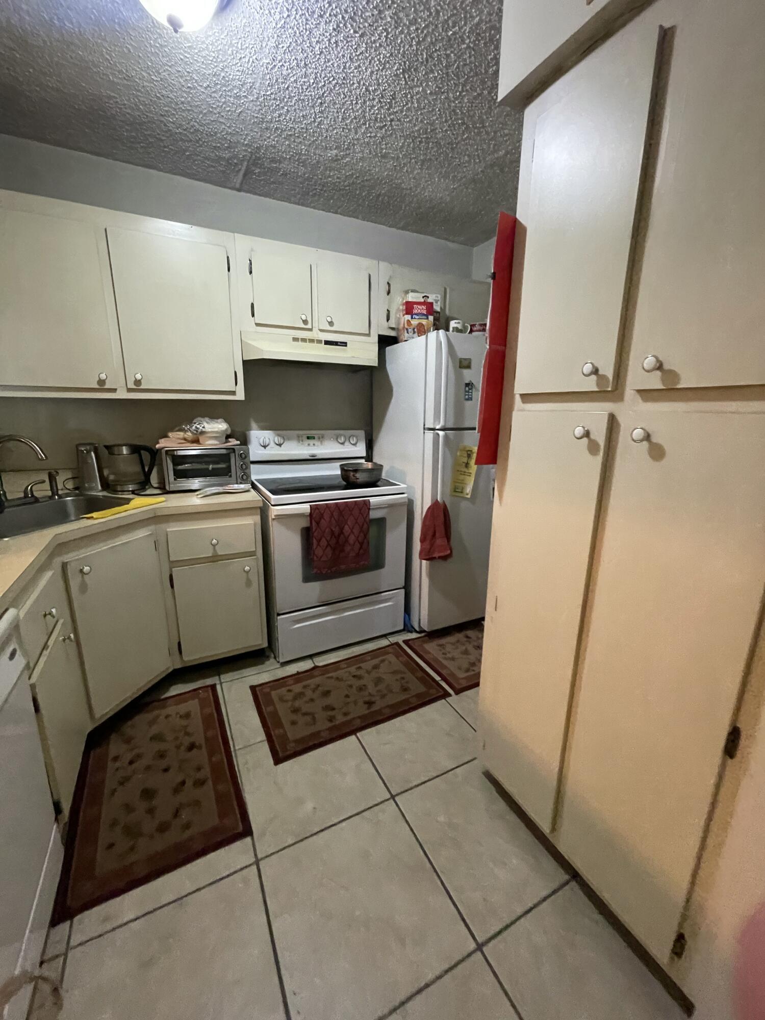 812 Sky Pine Way, Unit D1 Greenacres, FL 33415 - Photo 5 of 17 a kitchen with a sink a refrigerator and cabinets