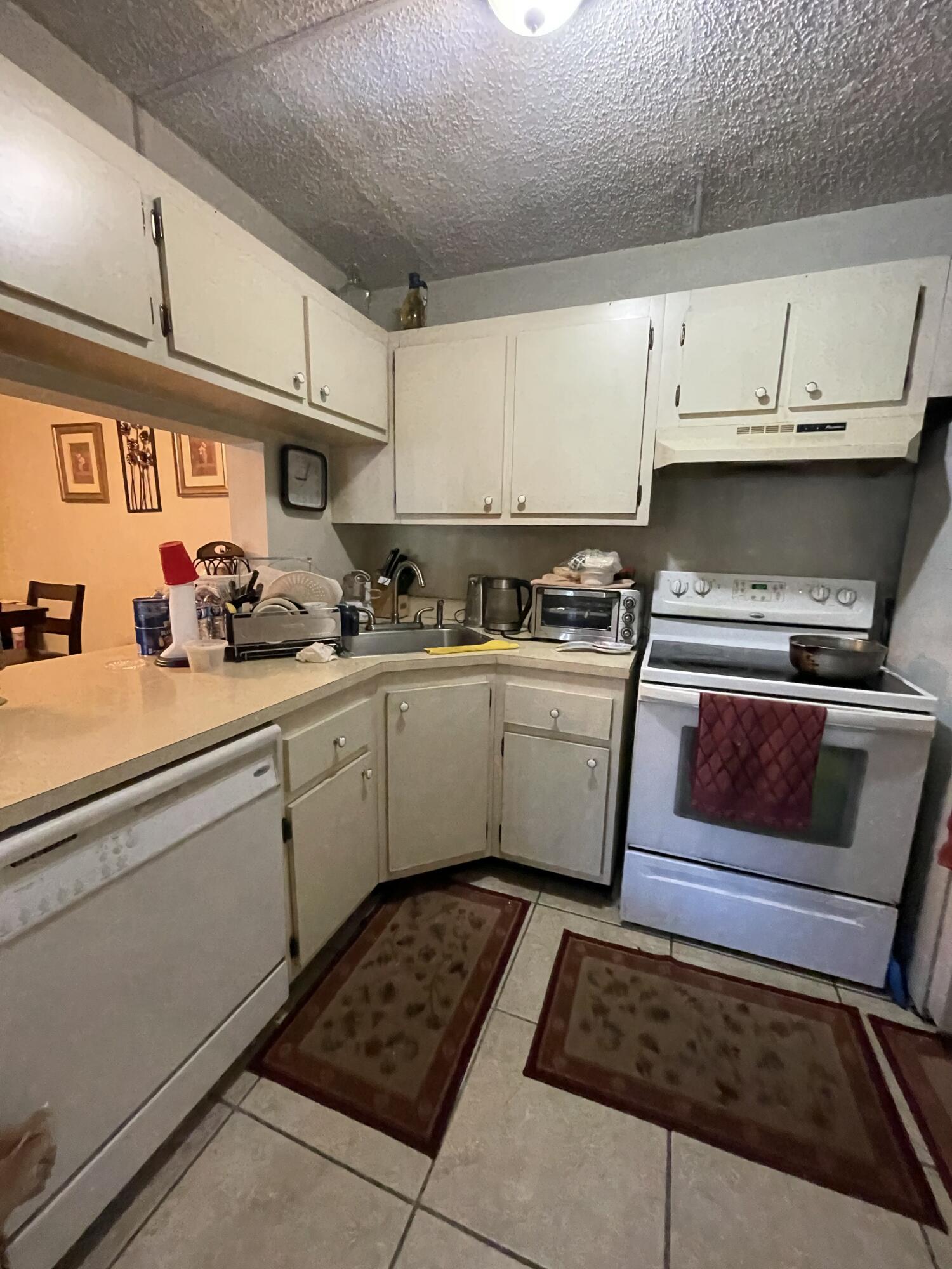 812 Sky Pine Way, Unit D1 Greenacres, FL 33415 - Photo 6 of 17 a kitchen with a sink stove and cabinets