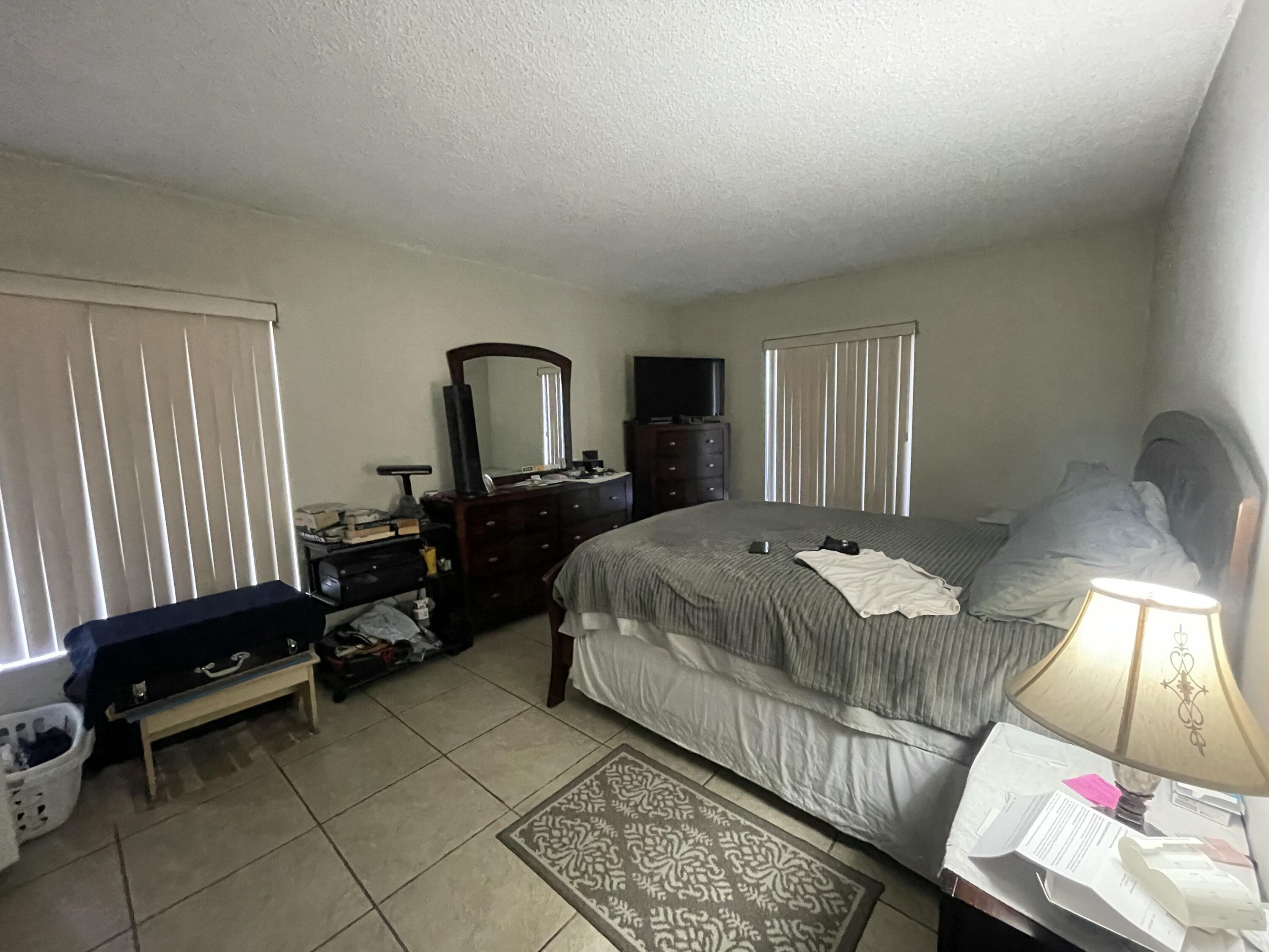 812 Sky Pine Way, Unit D1 Greenacres, FL 33415 - Photo 10 of 17 a bedroom with a bed and a mirror