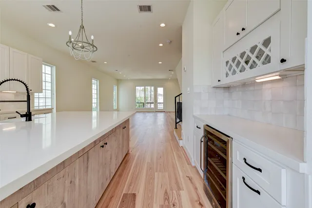 a kitchen with kitchen island a stove a sink a center island and windows