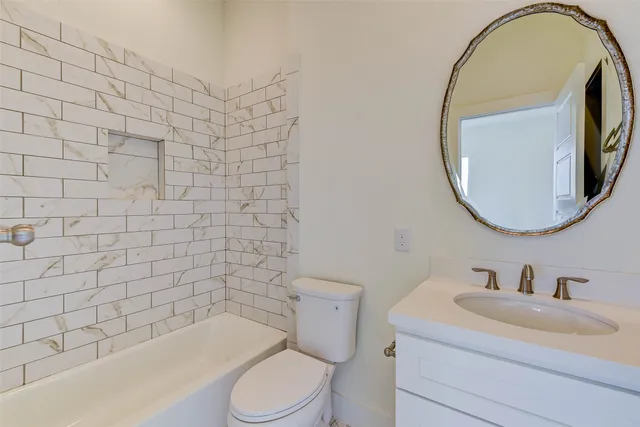 a bathroom with a granite countertop sink a toilet a mirror and shower