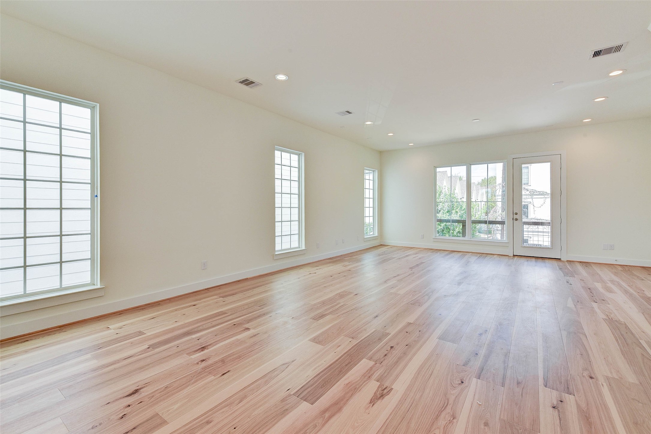 2516 Ohsfeldt Street Houston, TX 77008 - Photo 6 of 24 an empty room with wooden floor and windows