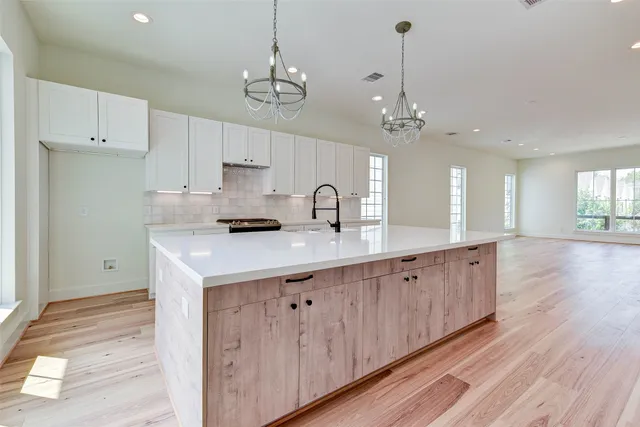 a kitchen with kitchen island a counter top space a sink stainless steel appliances and cabinets