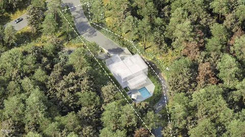 an aerial view of a house with a yard and large trees