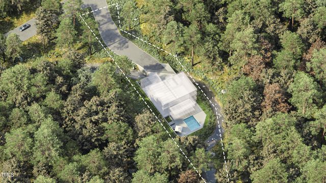 an aerial view of a house with a yard and large trees