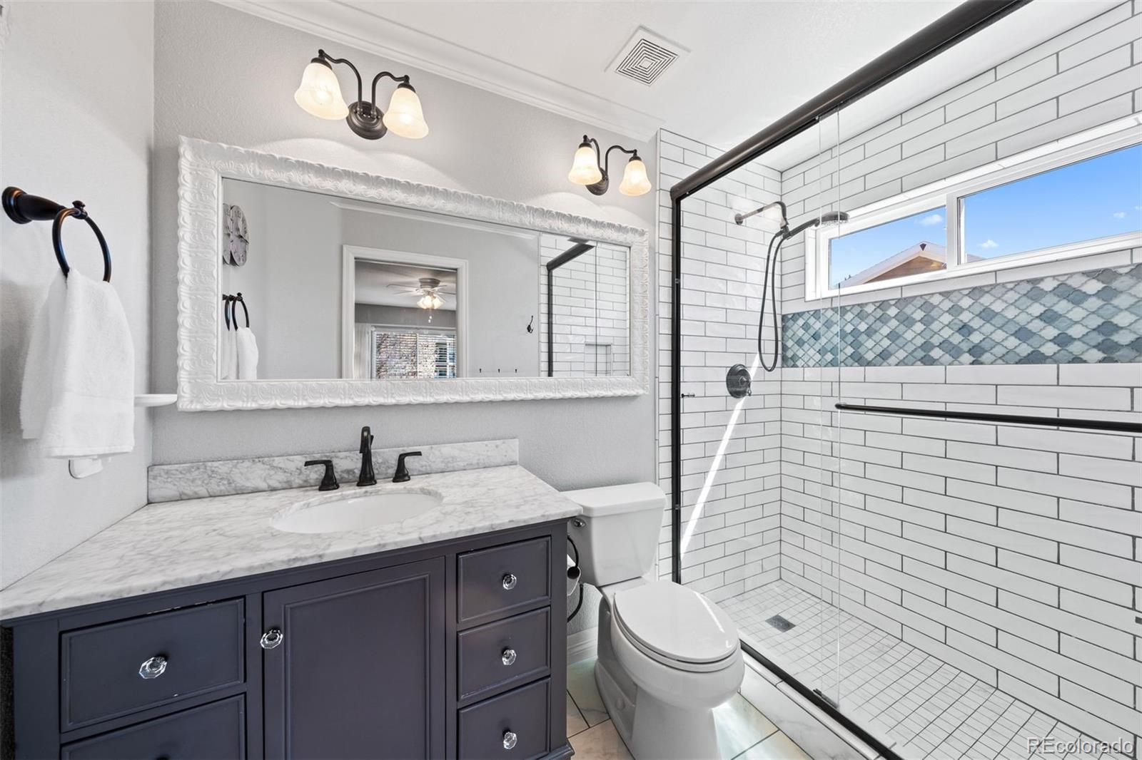 10289 South Dan Court Highlands Ranch, CO 80130 - Photo 21 of 36 a bathroom with a granite countertop toilet sink and mirror