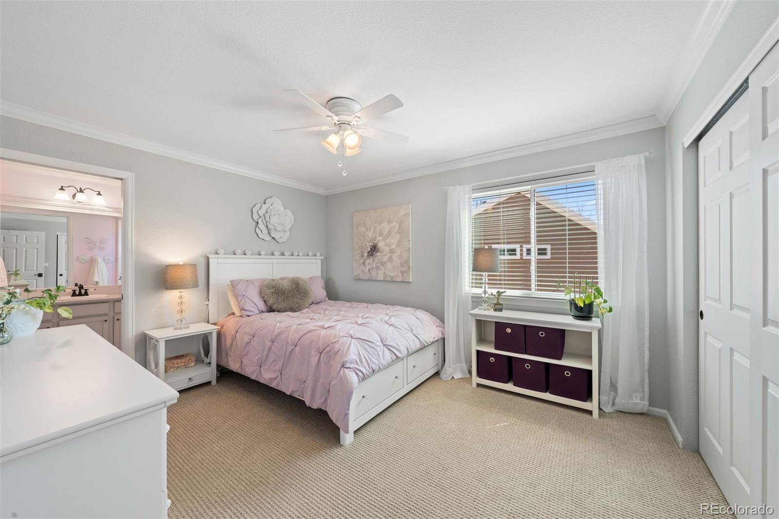 10289 South Dan Court Highlands Ranch, CO 80130 - Photo 22 of 36 a spacious bedroom with two beds and a chandelier