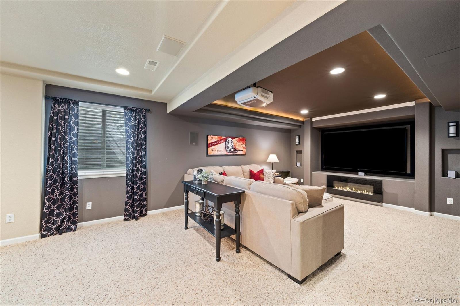 10289 South Dan Court Highlands Ranch, CO 80130 - Photo 28 of 36 a living room with furniture and a flat screen tv
