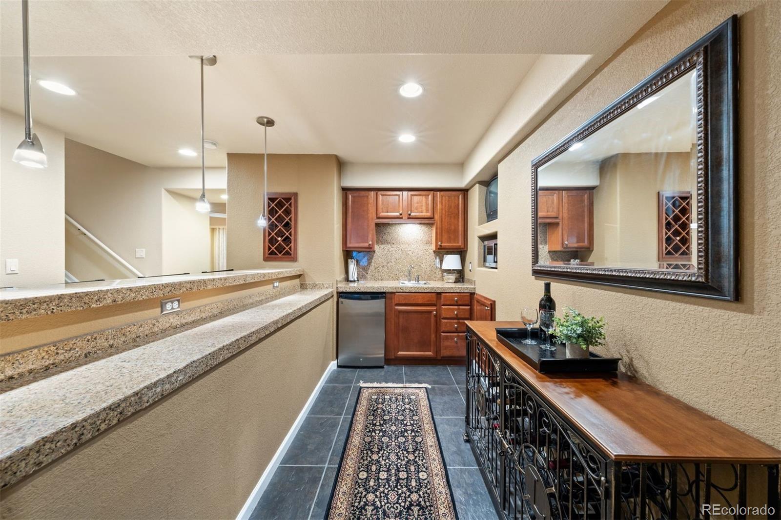 10289 South Dan Court Highlands Ranch, CO 80130 - Photo 29 of 36 a large white kitchen with a large window a sink and stainless steel appliances