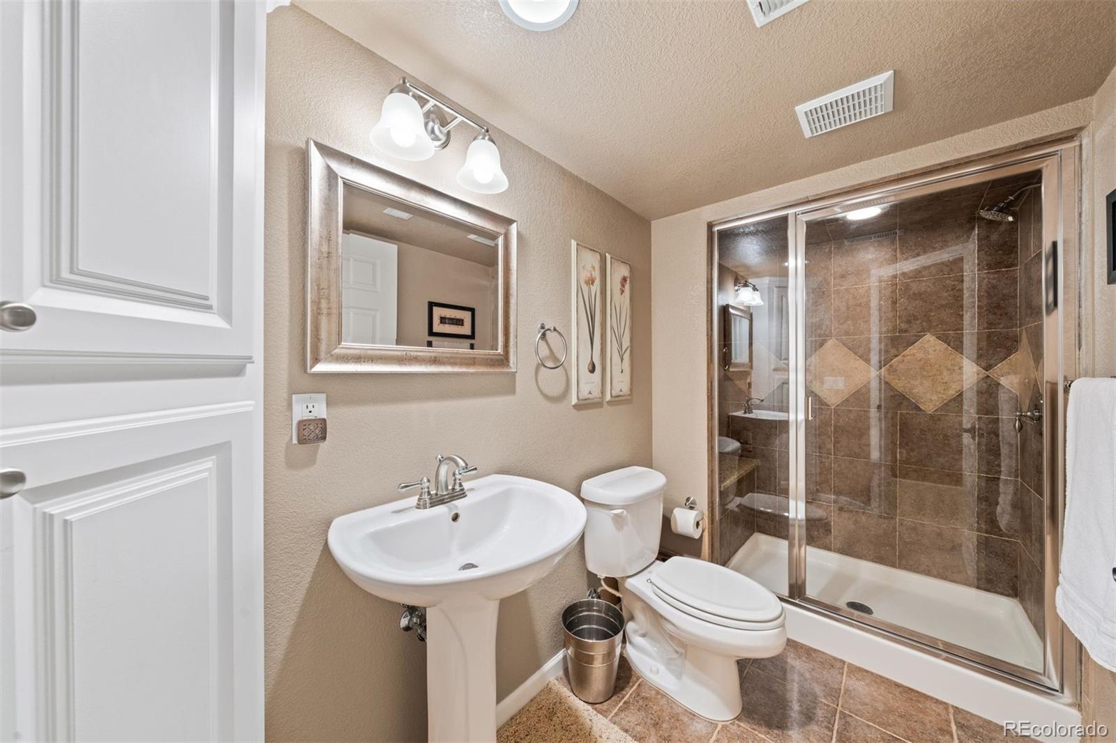 10289 South Dan Court Highlands Ranch, CO 80130 - Photo 33 of 36 a bathroom with a sink toilet and shower