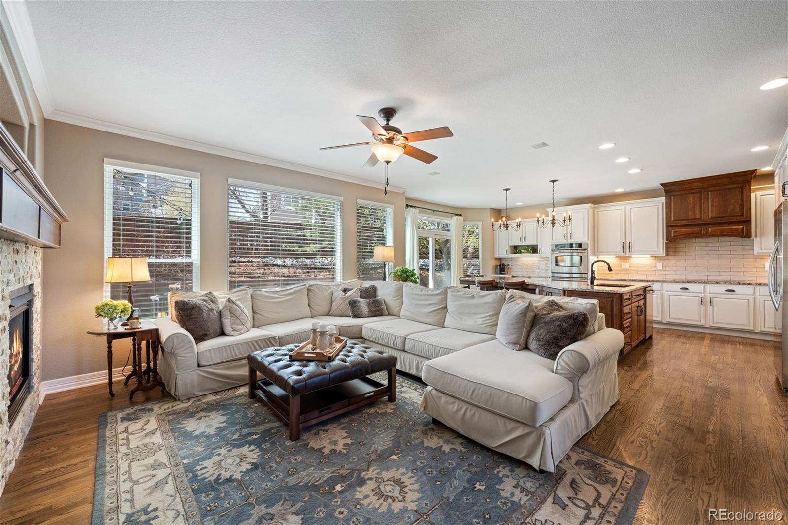 10289 South Dan Court Highlands Ranch, CO 80130 - Photo 7 of 36 a living room with furniture ceiling fan and a fireplace