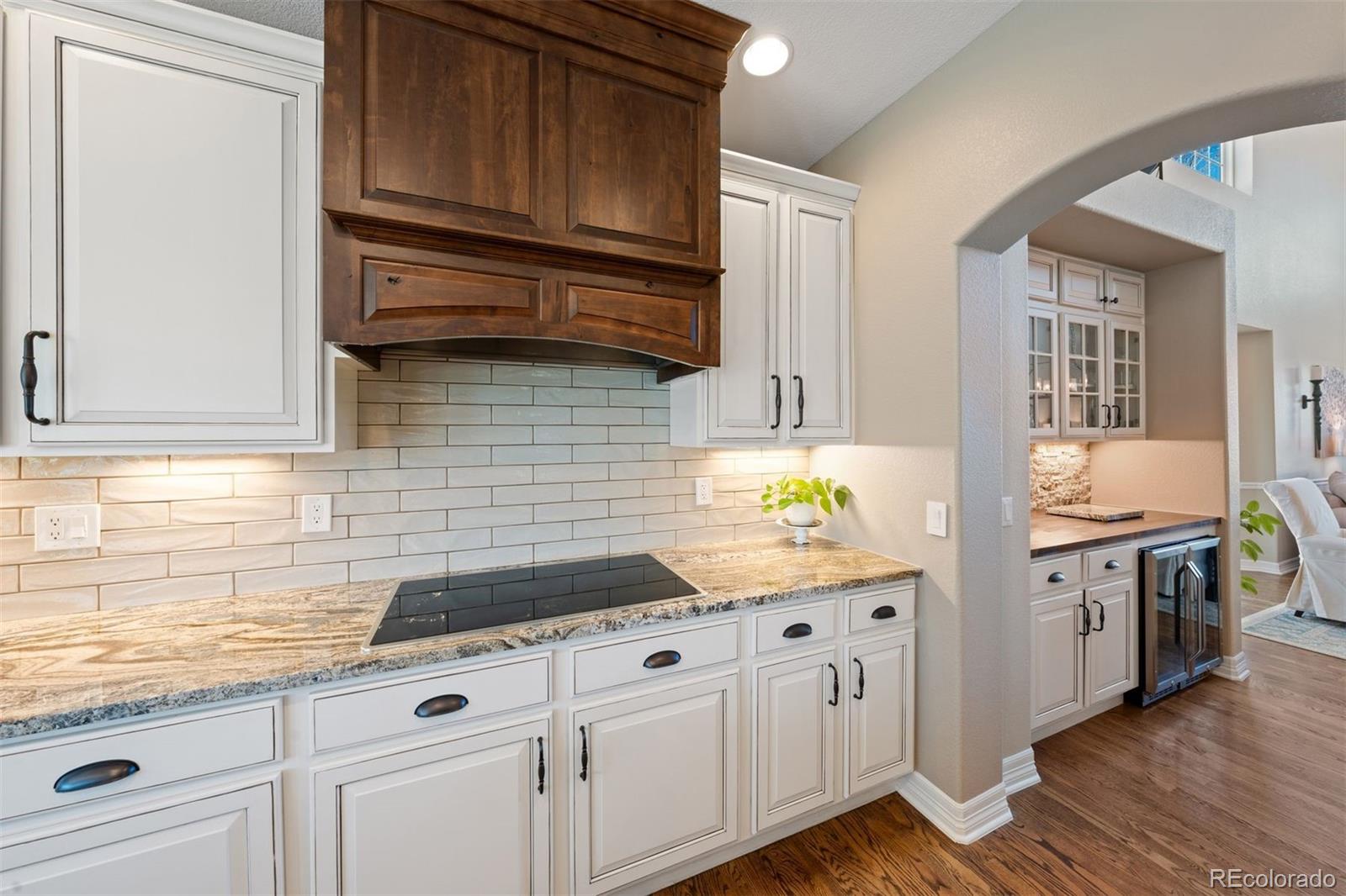10289 South Dan Court Highlands Ranch, CO 80130 - Photo 10 of 36 a kitchen with granite countertop cabinets stainless steel appliances and wooden floor