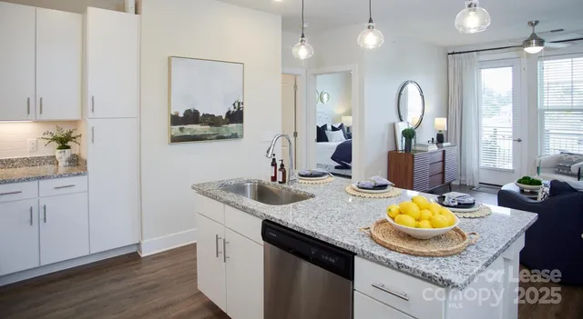 a kitchen with granite countertop kitchen island stainless steel appliances a dining table and chairs