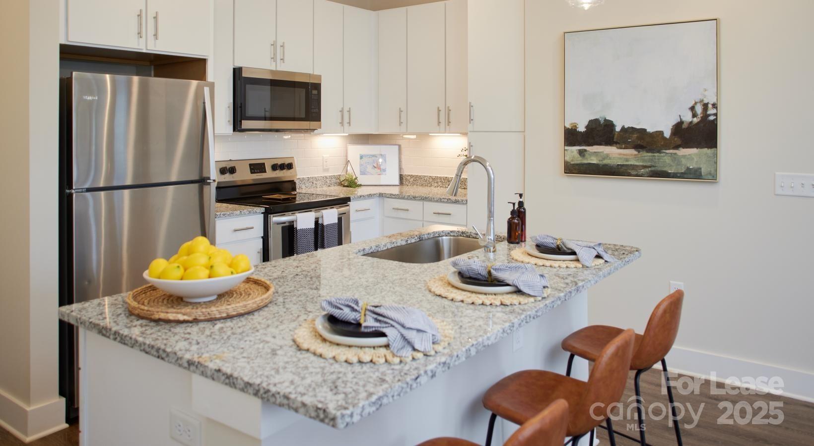 4101 Glenloch Circle, Unit B1 Matthews, NC 28105 - Photo 22 of 28 a kitchen with granite countertop kitchen island stainless steel appliances a dining table and chairs