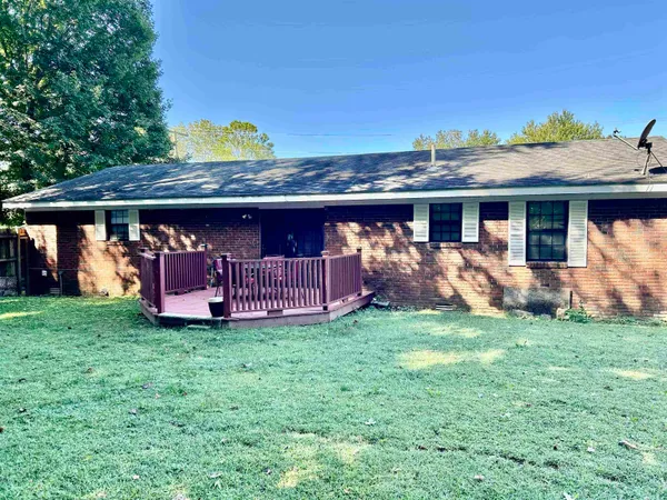 a view of a house with backyard and a tree