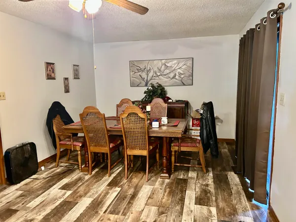 a dining room with wooden floor a chandelier a wooden table and chairs