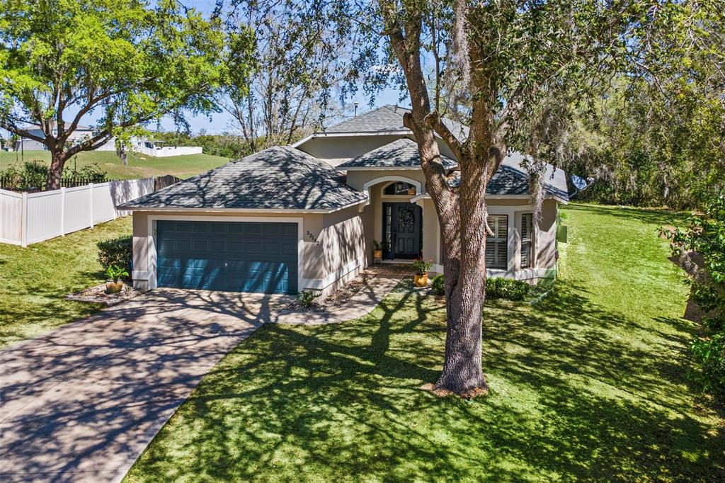 33142 Kaylee Way Leesburg, FL 34788 - Photo 1 of 45 a front view of a house with garden
