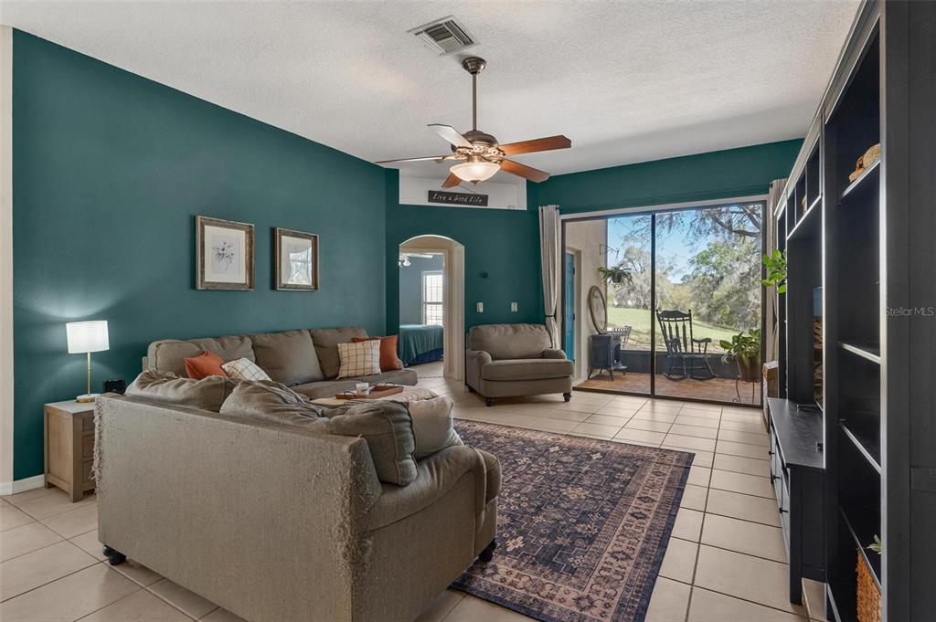 33142 Kaylee Way Leesburg, FL 34788 - Photo 11 of 45 a living room with furniture chandelier and a fireplace