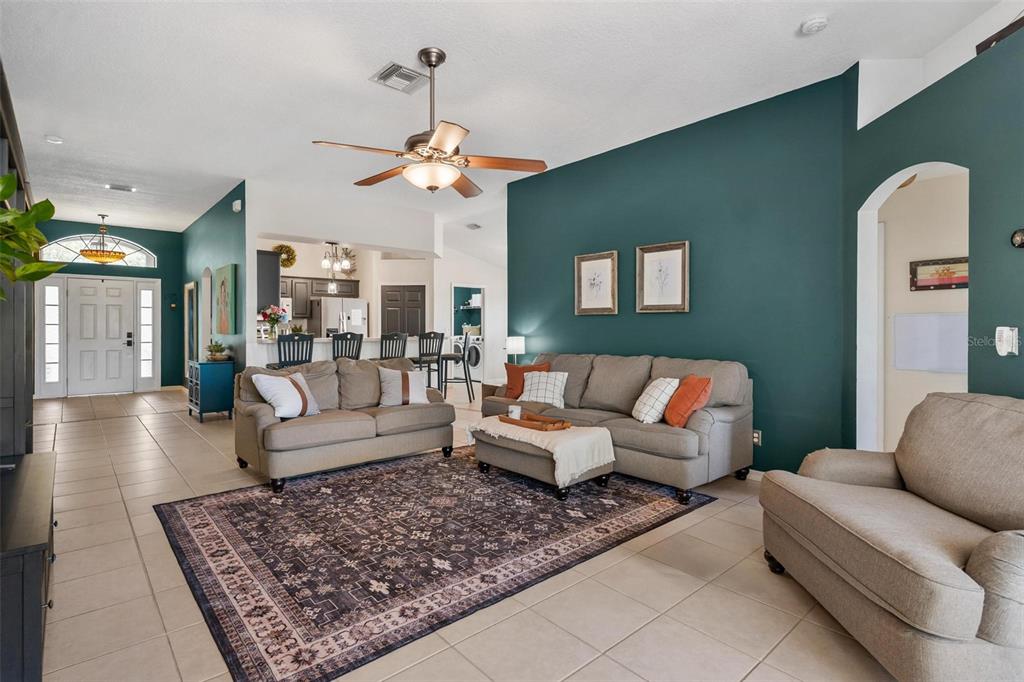 33142 Kaylee Way Leesburg, FL 34788 - Photo 13 of 45 a living room with furniture a rug and a chandelier