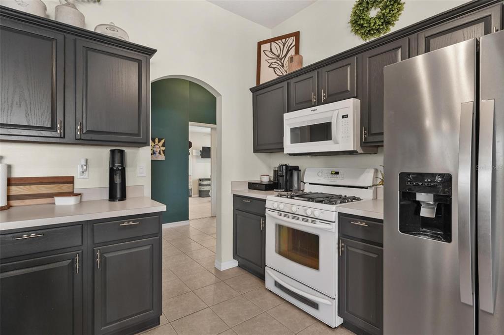33142 Kaylee Way Leesburg, FL 34788 - Photo 19 of 45 a kitchen with stainless steel appliances granite countertop a refrigerator stove and microwave