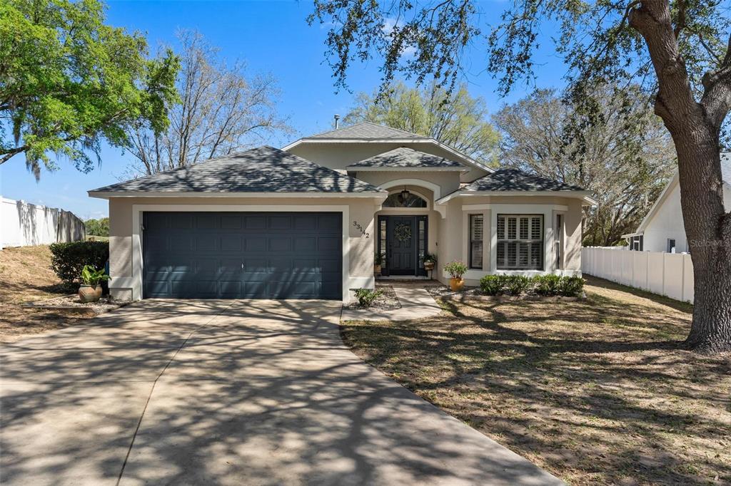 33142 Kaylee Way Leesburg, FL 34788 - Photo 2 of 45 a front view of a house with a garden