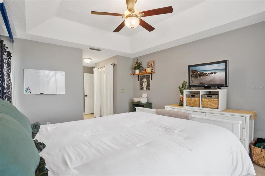 33142 Kaylee Way Leesburg, FL 34788 - Photo 24 of 45 a bedroom with a large bed and a chandelier