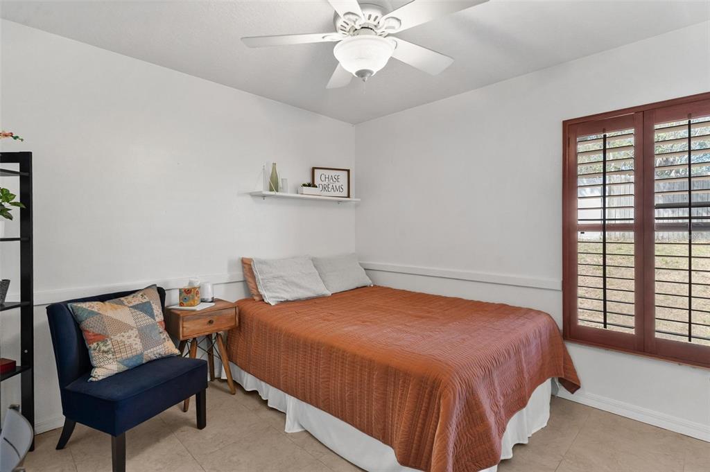33142 Kaylee Way Leesburg, FL 34788 - Photo 32 of 45 a bedroom with a bed and a chandelier