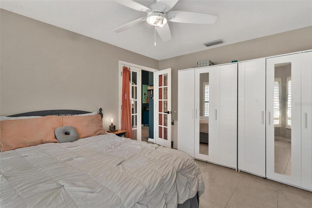 33142 Kaylee Way Leesburg, FL 34788 - Photo 35 of 45 a bedroom with a large bed and a chandelier