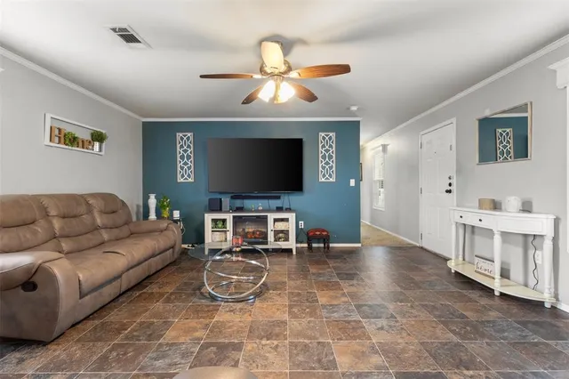 a living room with furniture a flat screen tv and kitchen view