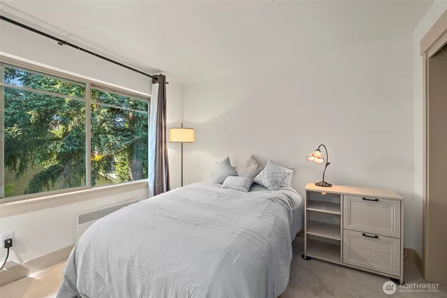 a bedroom with a bed and a large window