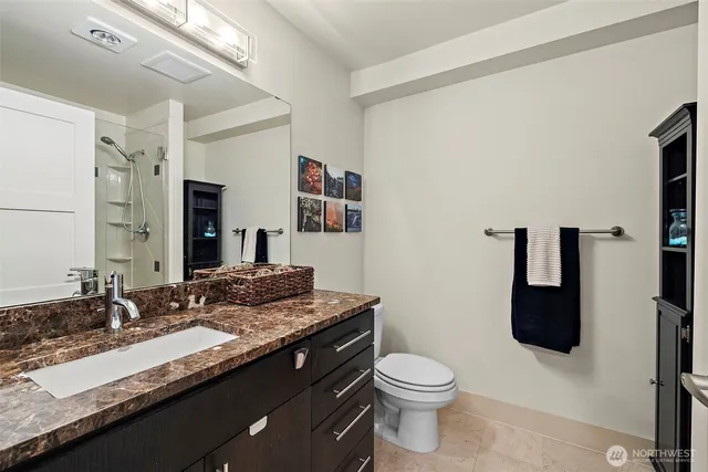 a bathroom with a granite countertop sink and a mirror