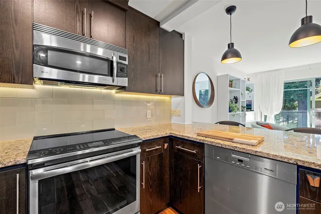a kitchen with stainless steel appliances granite countertop a sink refrigerator and cabinets