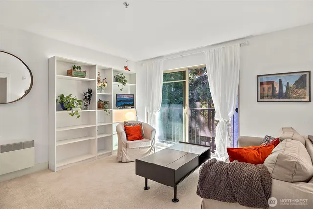 a living room with furniture a rug and kitchen view