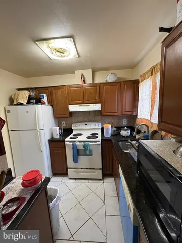 a kitchen with a stove a sink and a refrigerator