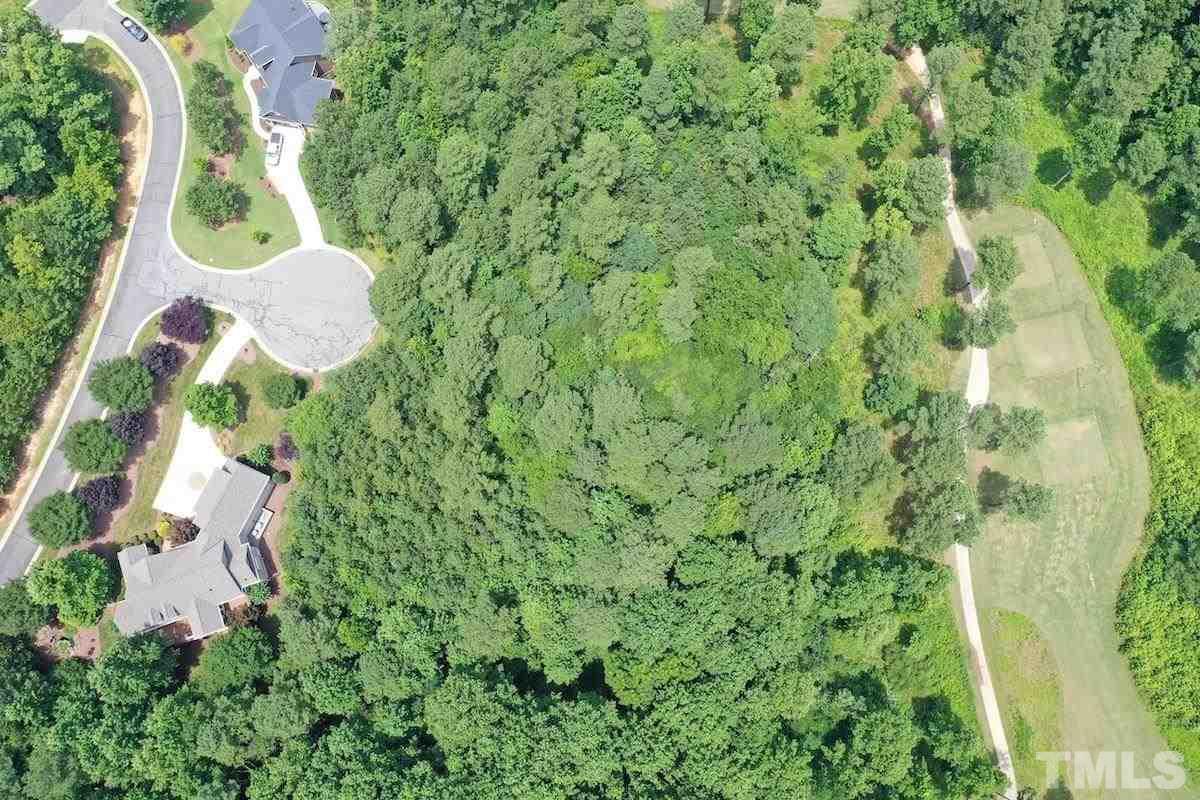 an aerial view of residential house with outdoor space and trees all around