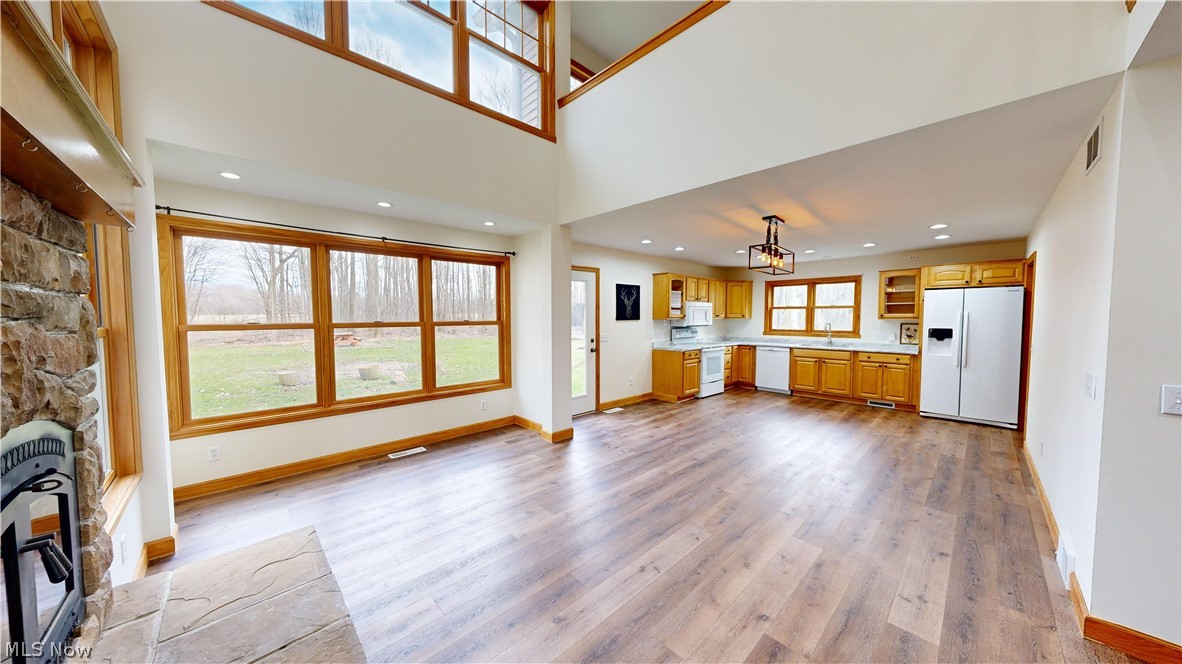 15548 Trask Road Thompson, OH 44086 - Photo 5 of 31 Unfurnished living room with sink, light wood-type flooring, and a stone fireplace
