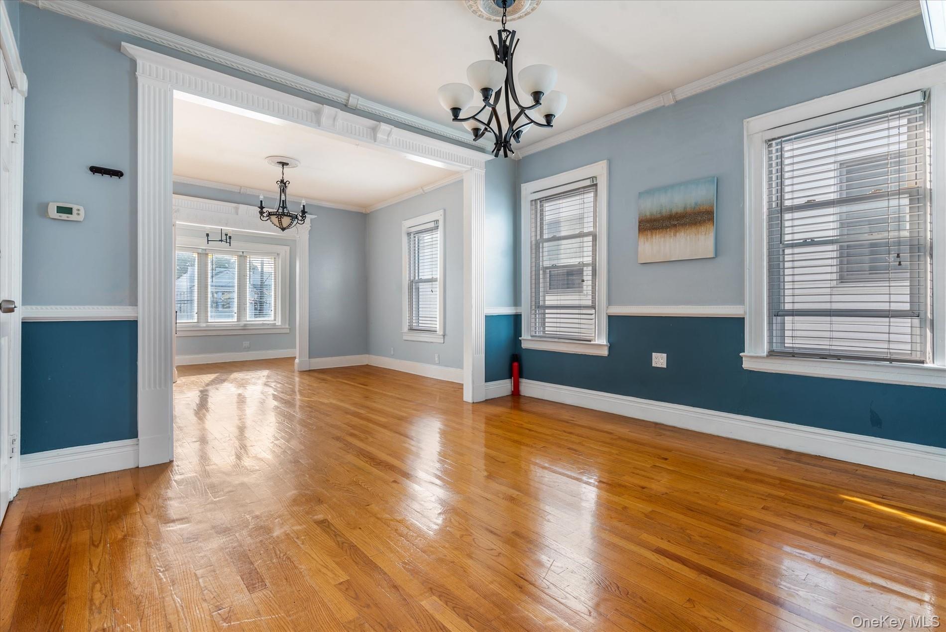 93-17 123rd Street Queens, NY 11419 - Photo 29 of 40 Unfurnished dining area featuring ornamental molding, hardwood / wood-style flooring, and a chandelier