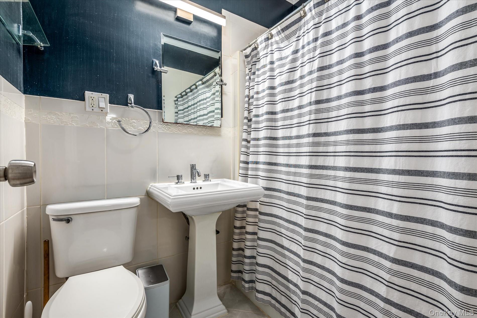 93-17 123rd Street Queens, NY 11419 - Photo 31 of 40 Full bath featuring a shower with shower curtain and tile walls