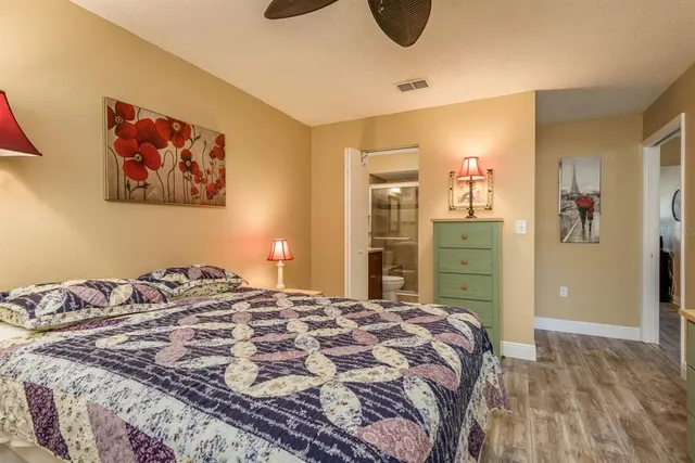 a bedroom with a bed and a painting on the wall