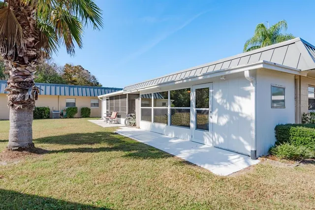 a view of a house with backyard and sitting area