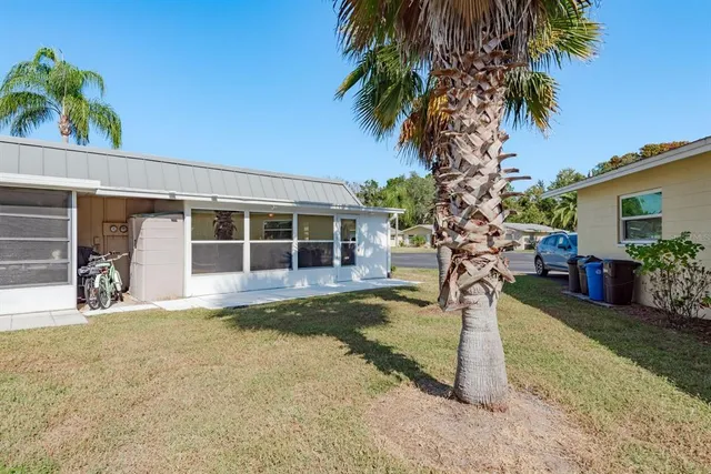 a front view of a house with garden and tree