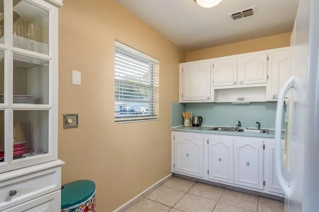a kitchen with granite countertop white cabinets and white appliances