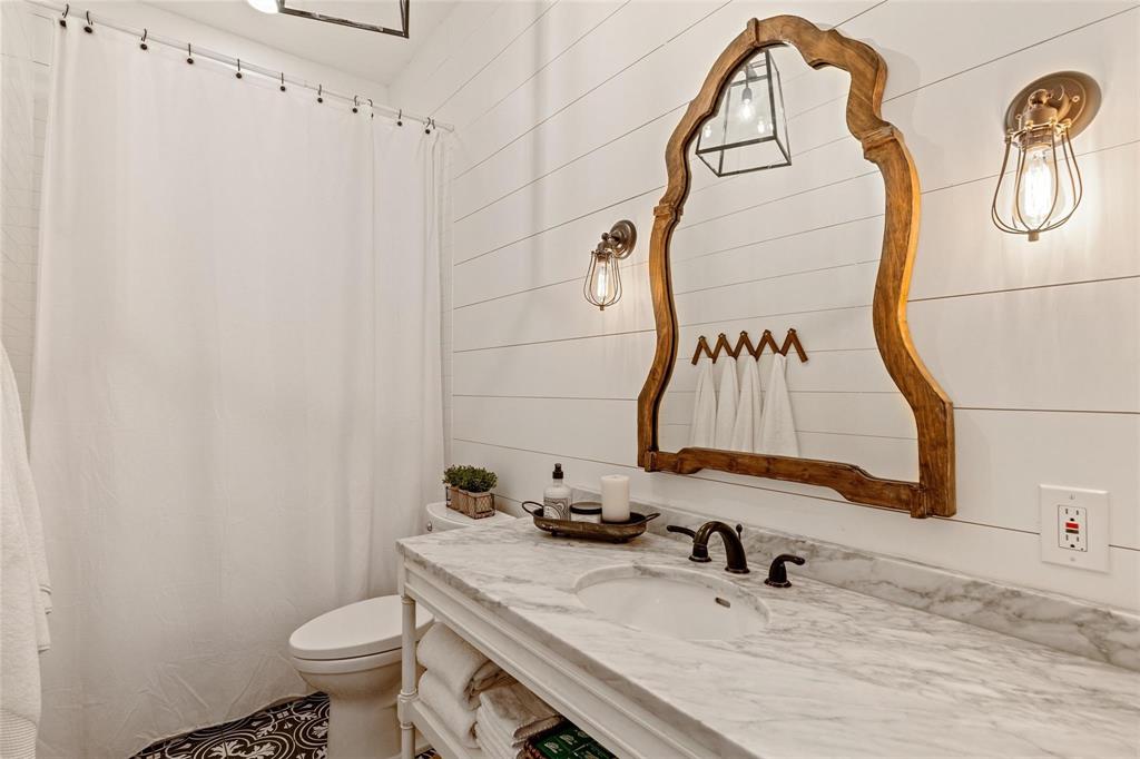 1109 East Oakdale Road Irving, TX 75060 - Photo 20 of 33 a bathroom with a sink and mirror with toilet